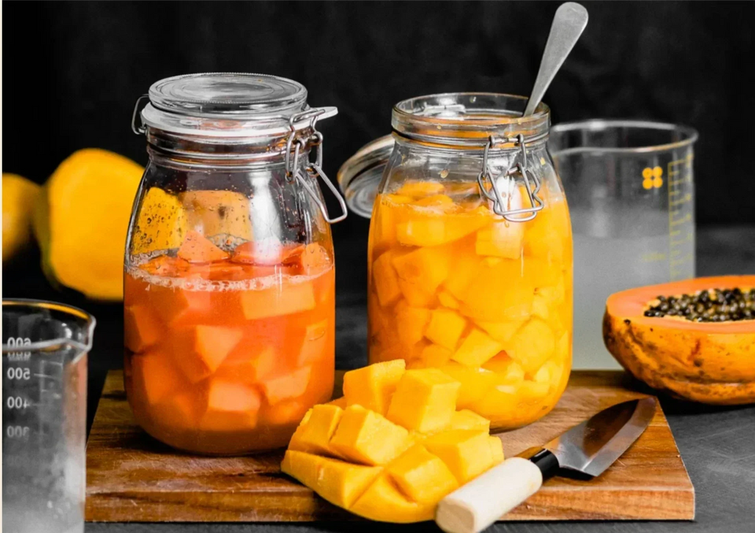 Raw fermented papaya in glass jars showing active fermentation process for natural skincare