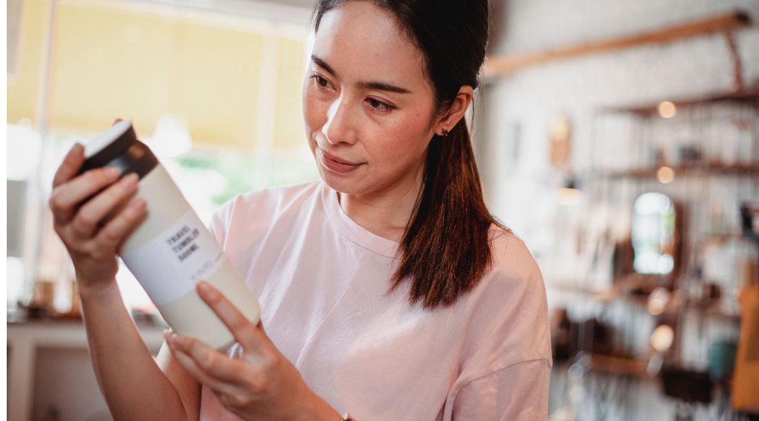 Woman reading a product label to check whether vegan skincare is natural