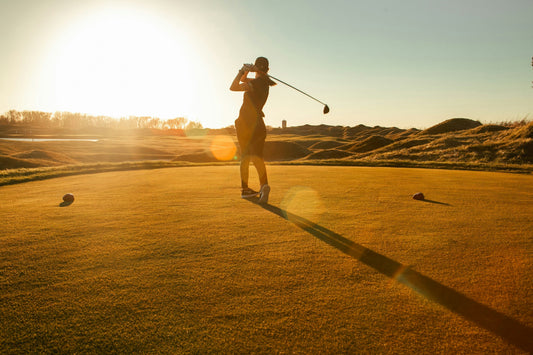 Woman golfer at sunset follow-through swing golden light - AYA Natural Skin holistic beauty blog