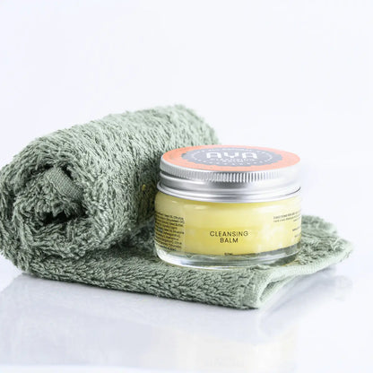 AYA Cleansing Balm 50ml glass jar with natural ingredients on sage green face cloth